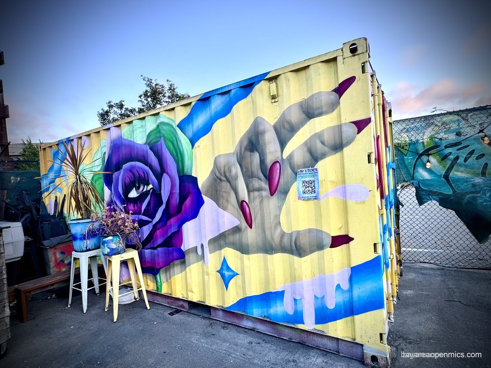 A mural painted across a shipping container behind 7th West