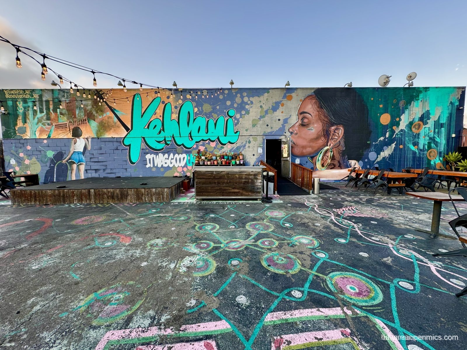 A large mural covering a wall behind 7th West