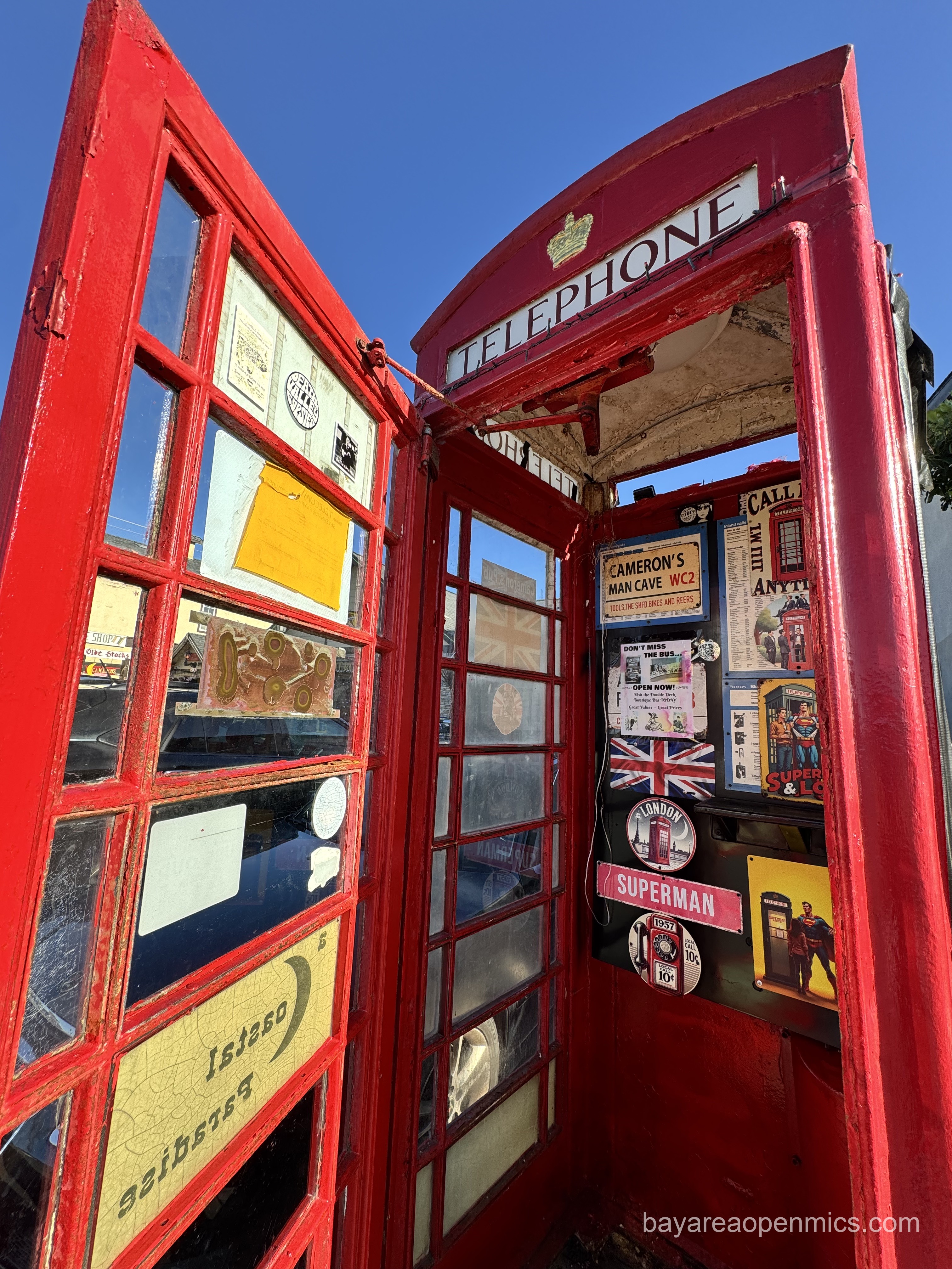 a red london phone booth with no phone inside with the door open