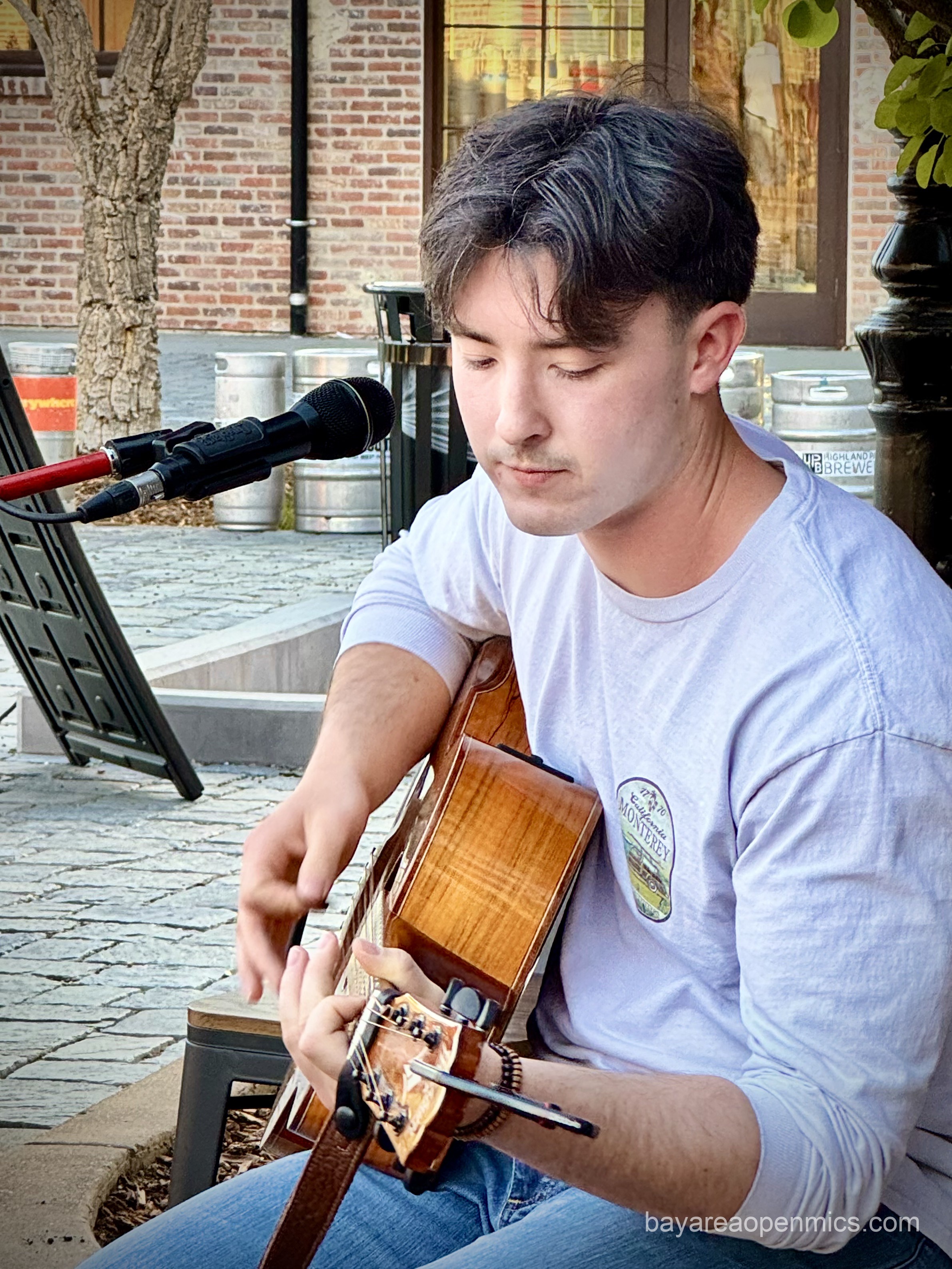 a young man sings passionately and plays guitar